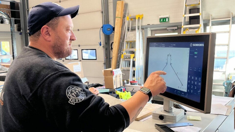 Frank Bøe legger inn tegning av mønebeslag på bukkemaskinen i verkstedet.