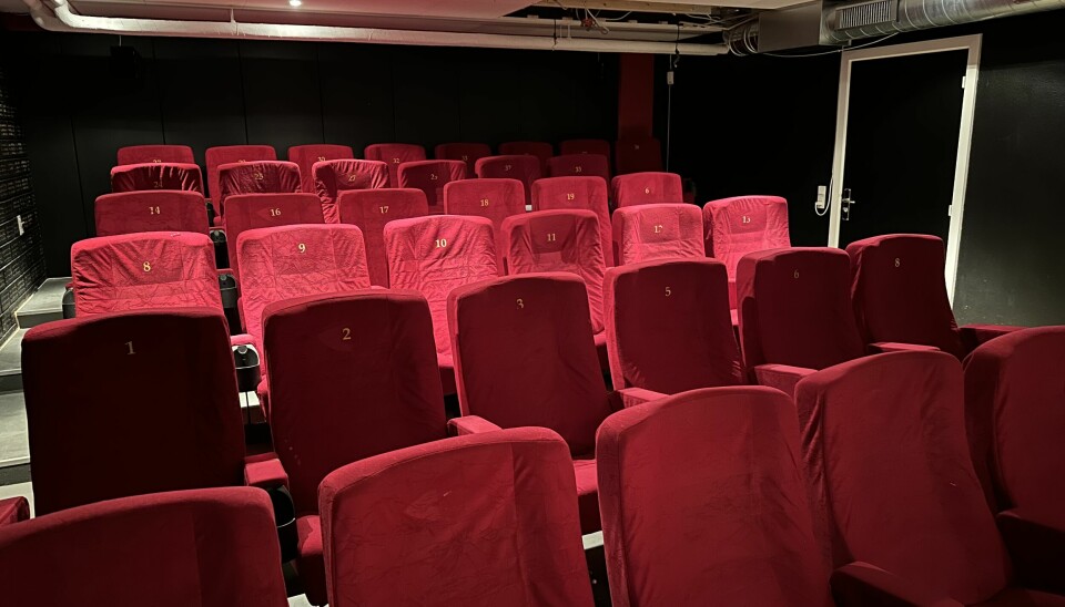 Tomme røde stoler i en kinosal.