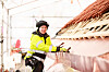 Blikkenslager i gule synlighetsklær arbeider på et kobbertak under stillas.