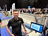Mann ved en berøringsskjerm på en travel teknologimesse.