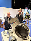 To personer ved en messestand med ventilasjonsrør.